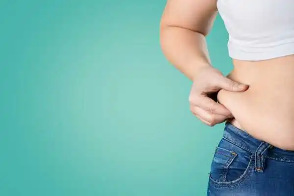 Image of woman pinching her love handles to show weight gain Gerrards Cross